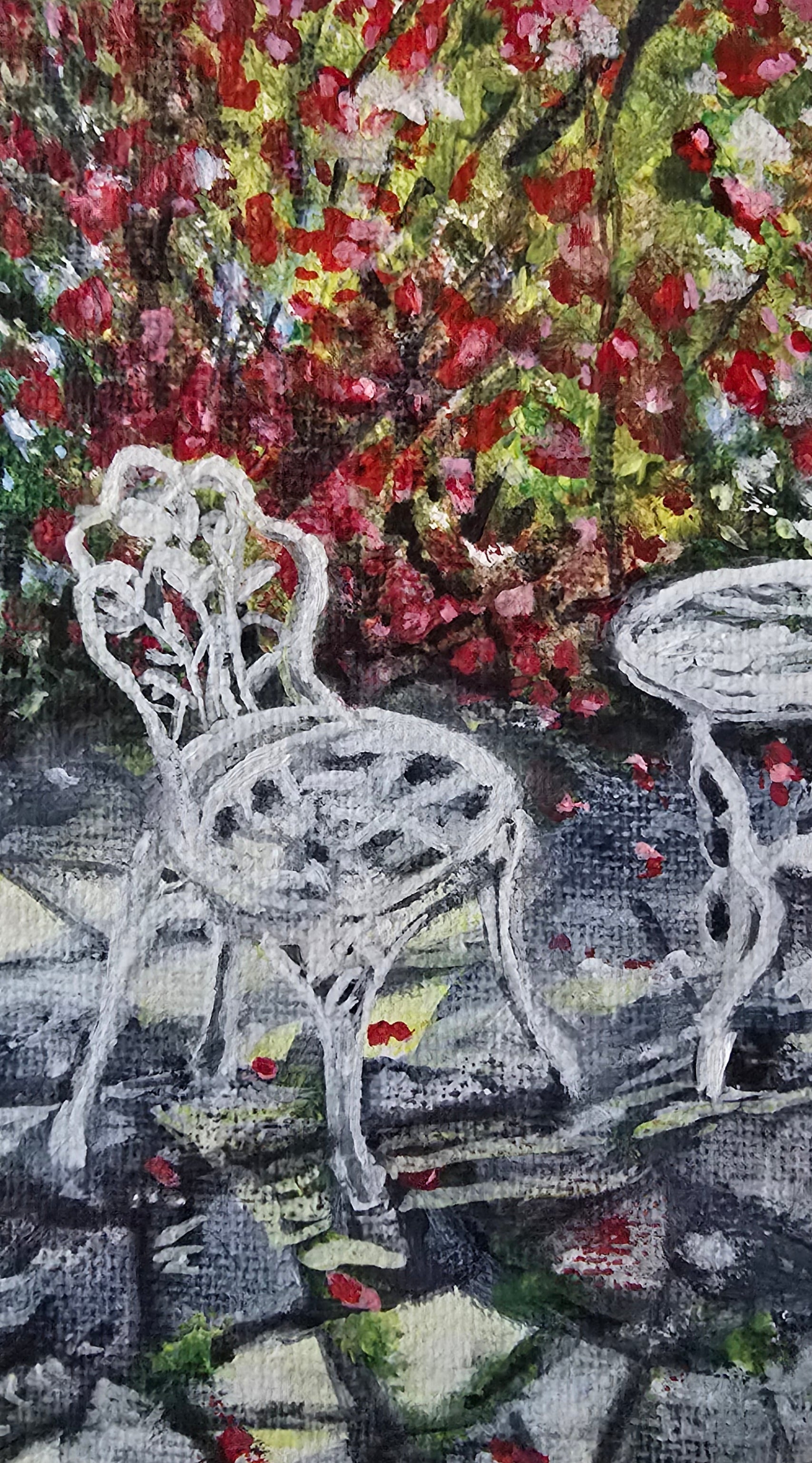 Close-up of a painting with a Bistro set  and floral elements on a textured surface.
