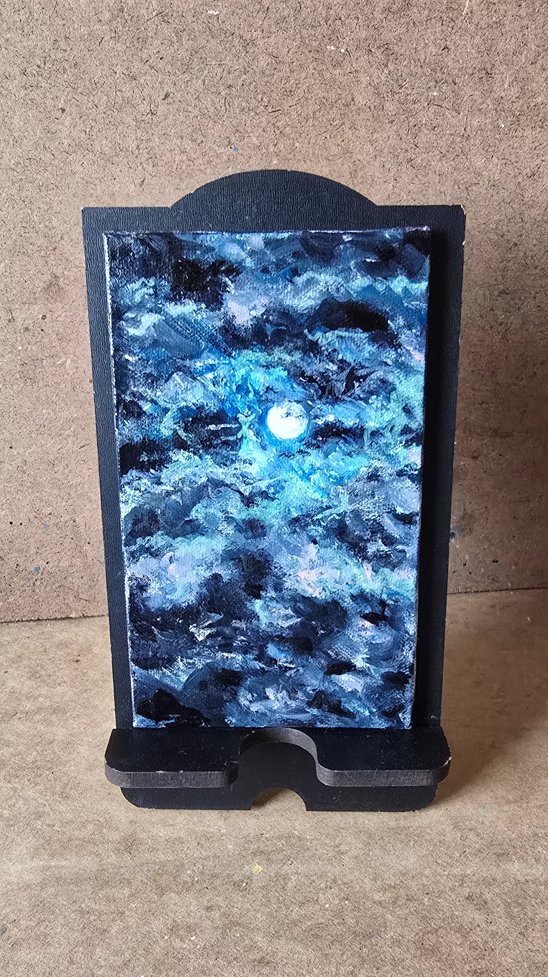 Blue stone slab on a black stand on a concrete floor