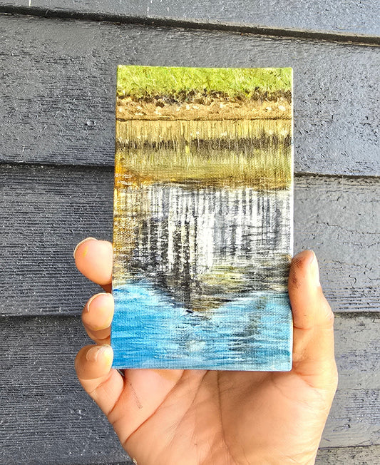 a tiny painting of water reflections of a building in greens and blues